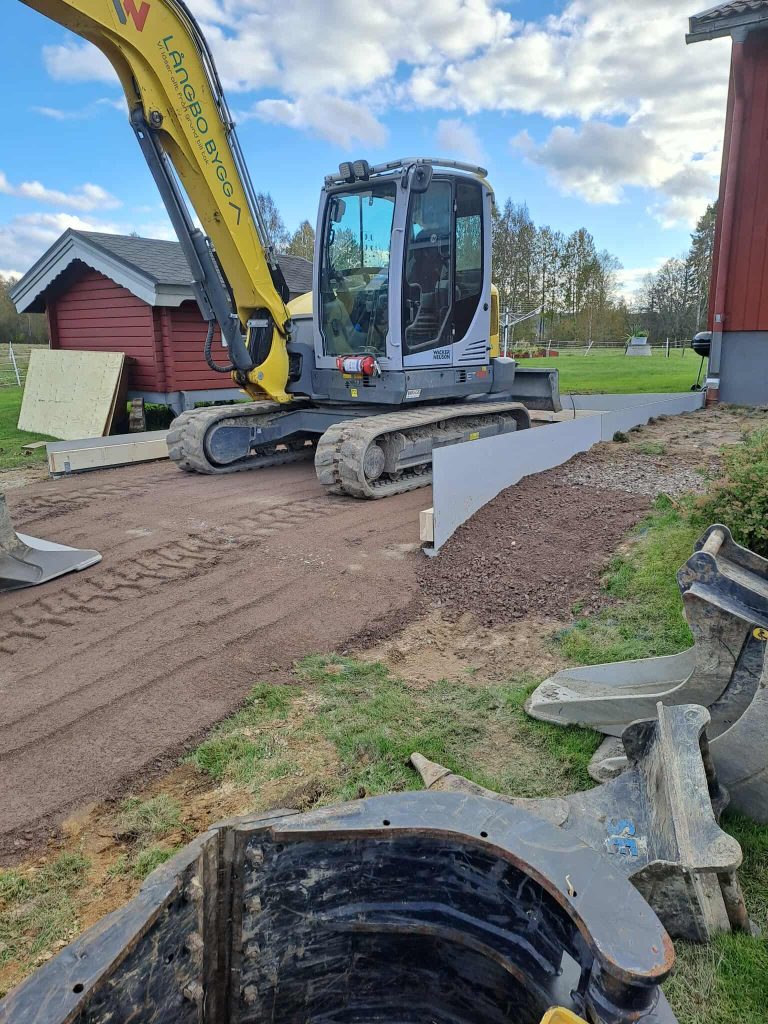 Grävmaskin vid dränering av röd villa